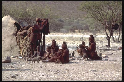 Himba Familie vor ihrer Hütte sitzend - Namibia