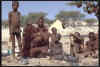 Himba Familie mit Behausung im Hintergrund - Namibia
